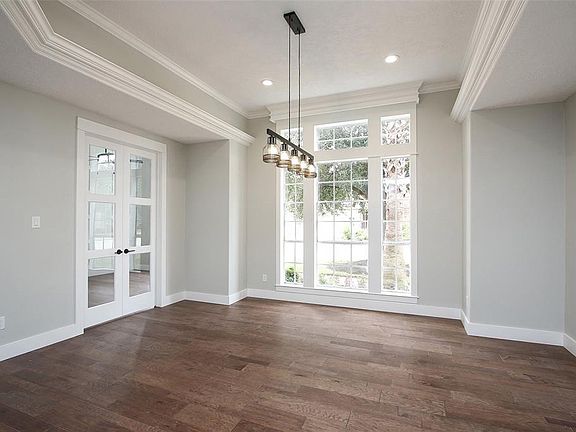 This isn't your grandmother's dining room. Just look at the trey ceiling, wall of windows, rich wood flooring and fabulous light fixture.