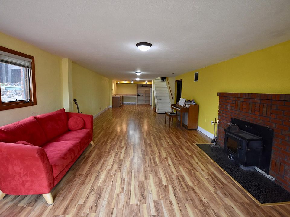 Large open living room and kitchen with fireplace and lots of natural light.