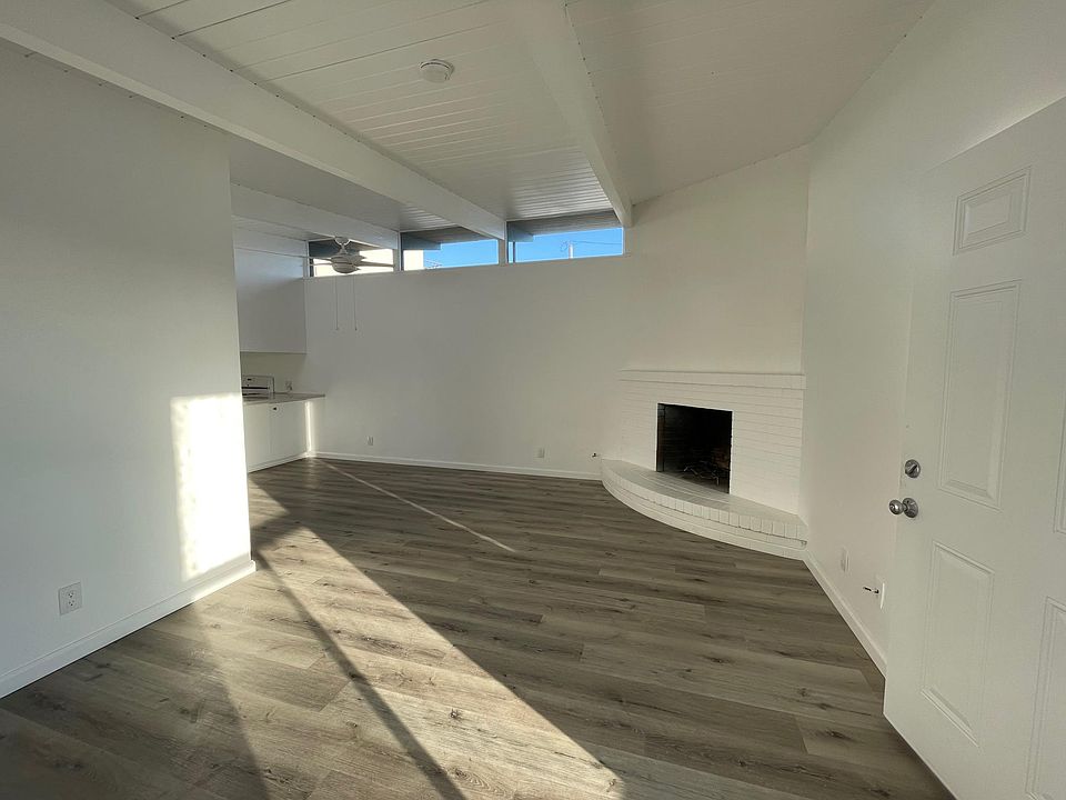 Living room, brand new hardwood-style floors, wood-burning fireplace, big windows, lots of light!