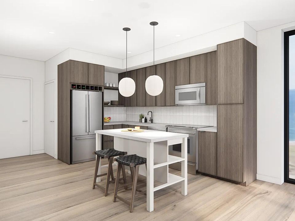 Gourmet kitchens with quartz countertops, custom cabinetry, and tile backsplash at Modera Revere Beach in Revere, MA.