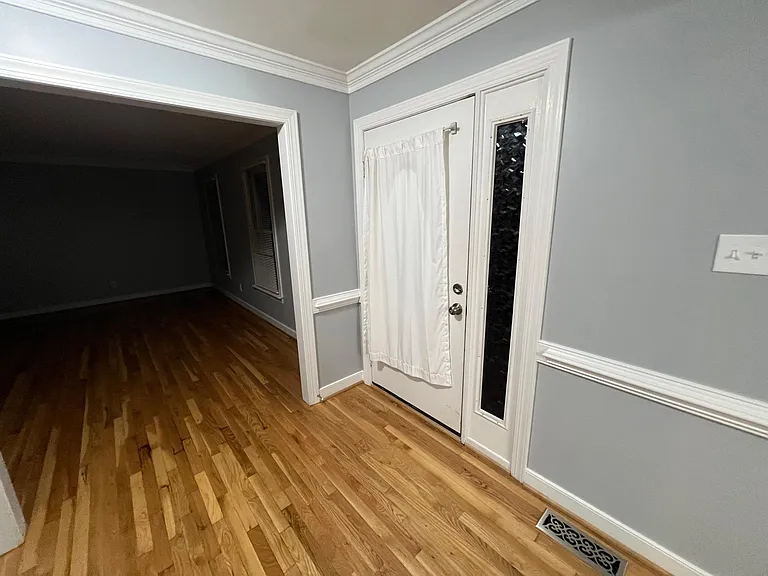 Photo of front door, living room/office space pictured to the left