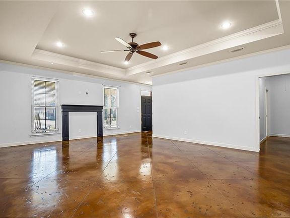 Unfurnished living room with baseboards, a fireplace, visible vents, and a raised ceiling