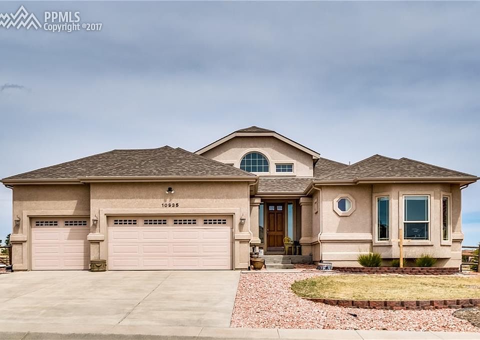 Front of home, stucco with three car garage.