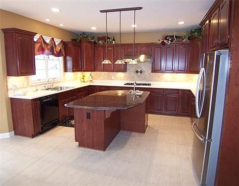 Gorgeous "dream" kitchen featuring cherry cabinets, a center island with a granite top, a "vegetable sink, pendant lighting & room for stools, 5-burner Thermador gas cooktop, Built-in oven and microwave, new tile backsplash plus a walk-in pantry