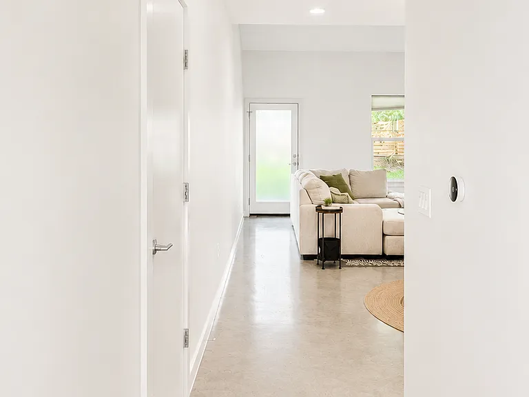 Hall entryway with Google Nest A/C control and guest bathroom on the left