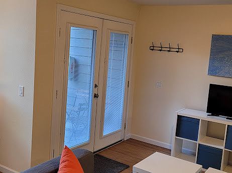 View looking back towards the double French door entrance from inside the unit. There are adjustible blinds inside the glass of the doors for privacy.