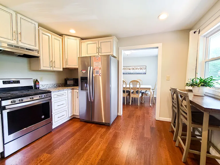 Beautifully equipped kitchen with granite countertops, custom cabinets, breakfast bar, and easy access to the dining room.