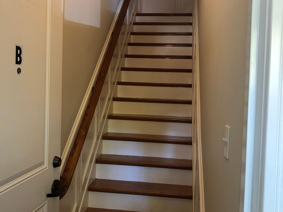 From the shared foyer, a beautiful staircase with custom wainscot