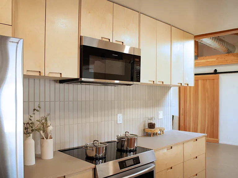 Fully equipped kitchen with stainless steel appliances and ample storage.