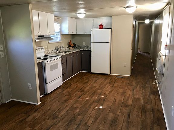 Open living area and kitchen. Wood like floor.