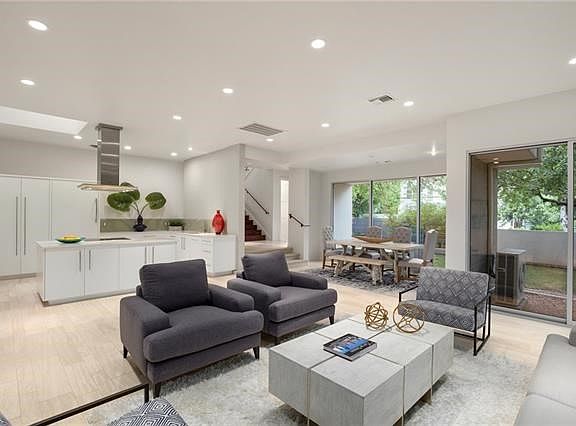 Open floor plan connects kitchen, dining, and living areas; remarkable windows bring elements of the courtyard to living space.