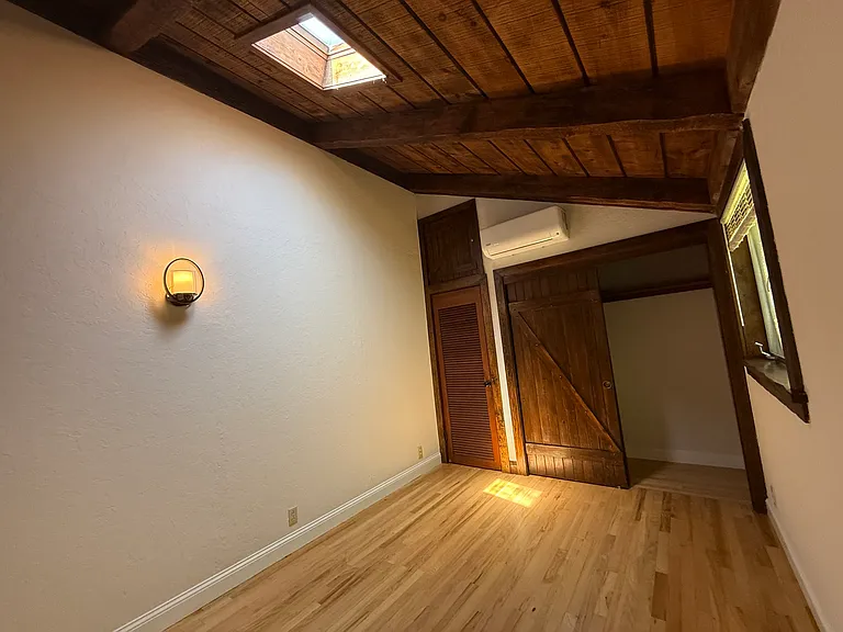 Bedroom #3 features wooden valuted ceiling, skylight, one window and 2 closets with a split AC cooling unit.