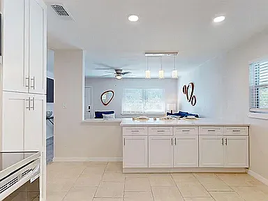 Spacious kitchen with ample cabinet space, stainless appliances, and pass-through to dining and living areas