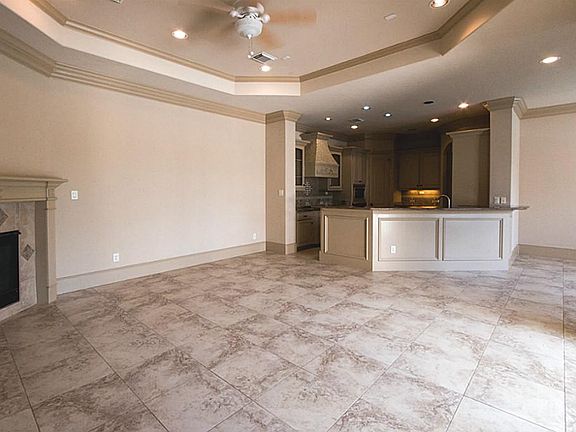 Living room (over look the pool) : fire place, crown molding, ceiling fan, tile floor