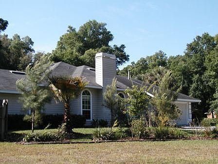 Side of house with palms and pines