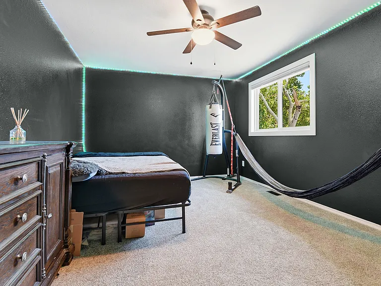 Spacious secondary bedroom with large windows, soft natural light, and plenty of room for guests, kids, or a home office.