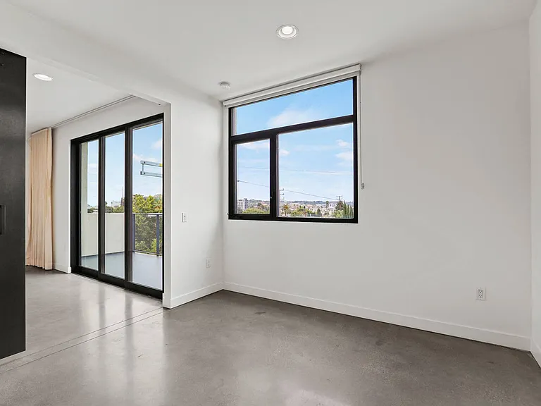 Bedroom with Large Windows, Concrete Flooring, and Recessed Lighting