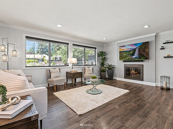 The cozy fireplace in the living room invites relaxation. A wall unit AC adds comfort on those hot summer days.