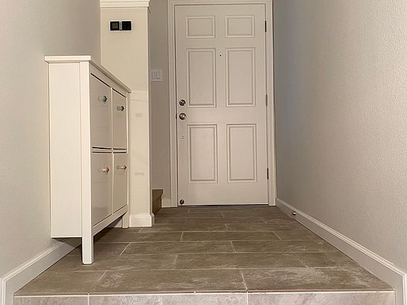 Custom tile entryway leads to a bright, open, and airy living room, creating a warm and welcoming first impression.
