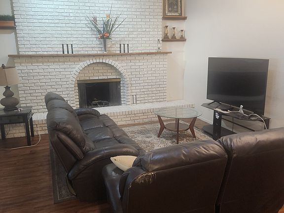 Living room and fireplace, leather couches and 70" TV.