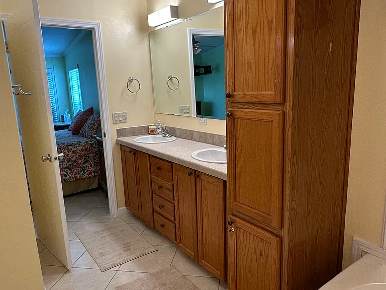 Master bath with double his and her sinks with large tub and oak cabinet storage! View #1