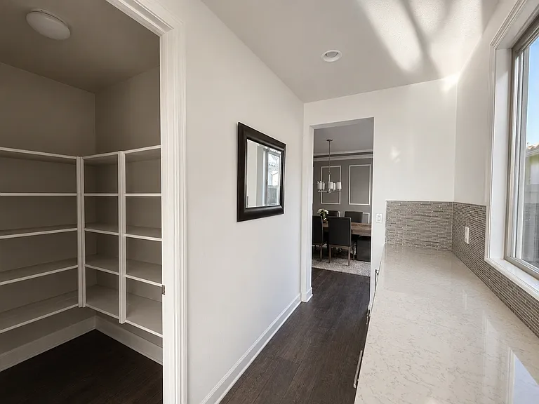 Butler's pantry and walk in pantry connecting kitchen to formal dining room