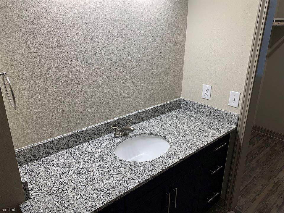 This bathroom features a large granite vanity and double ent