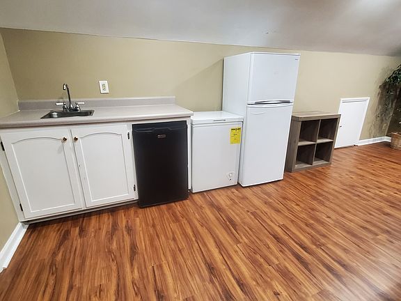 Mini kitchen area includes sink, deep chest freezer, beverage drink fridge and full size fridge