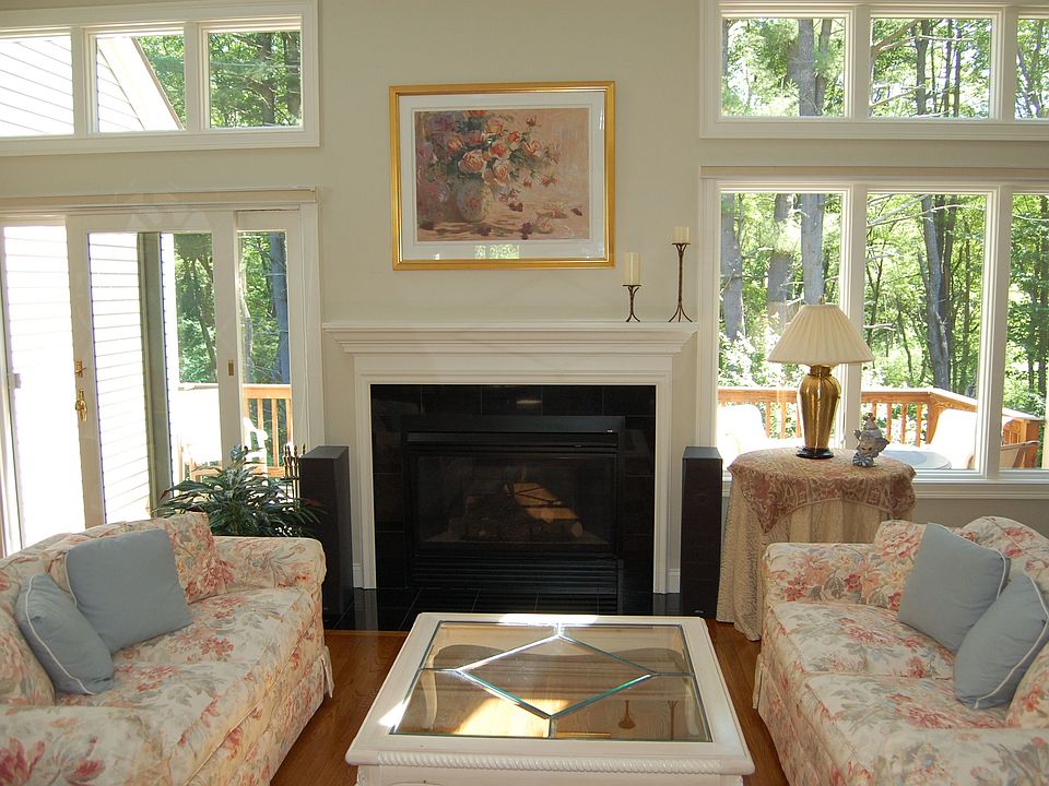 2-story livingroom with wall of windows to deck and woodland views