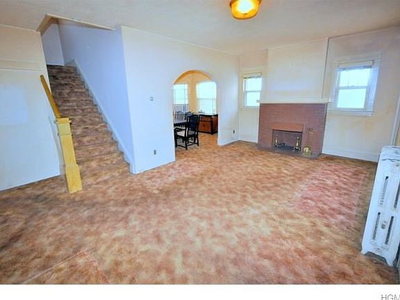 Large living room with wood burning fireplace, arched doorway to formal dining room and covered hard