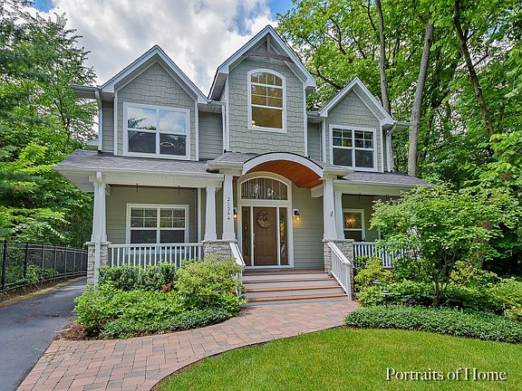 James Hardie Board siding and stone column accents, surrounded by beautiful woods.