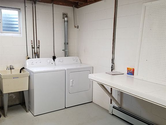 bright laundry room with new washer and dryer and lots of ro