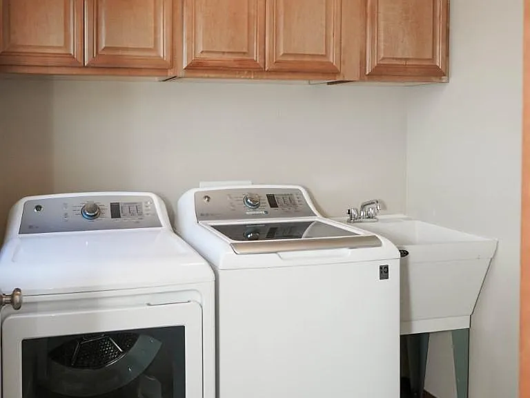 1st floor - Laundry room with newer washer/dryer, utility sink and cabinet storage.
