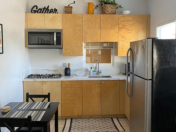 Kitchen - Spacious kitchen with dining area, full sized refrigerator, quartz countertop and range top.