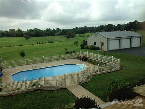 Beautiful ocean blue swimming pool, the perfect place to entertain and a breath taking view of 4 Acres and an additional 3 car detached garage.