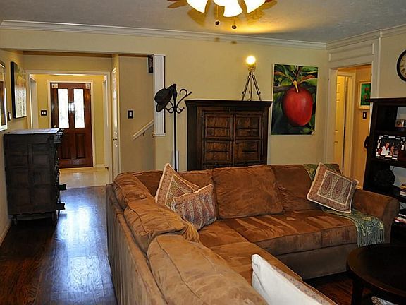 Elegant family room features crown molding, hardwood floors, gas log fireplace & ceiling fan.