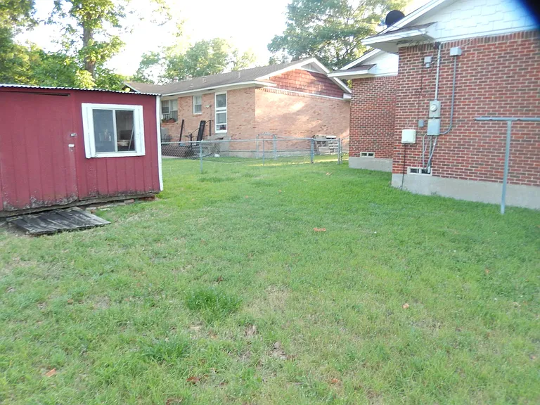 View of storage house on the left in the backyard