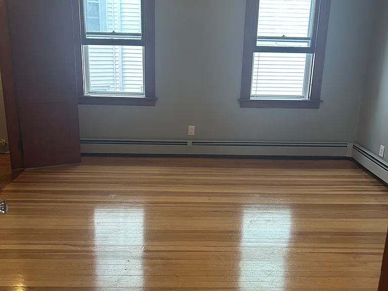 Bedroom with walk-in closet and hardwood floors