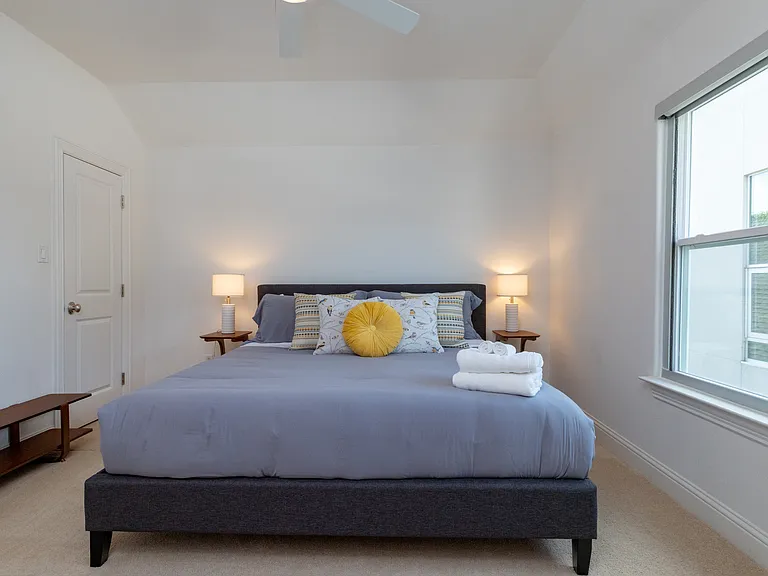 Bright and modern upstairs bedroom featuring a plush king-sized bed.
Relax in style with premium linens and a comfortable king bed.