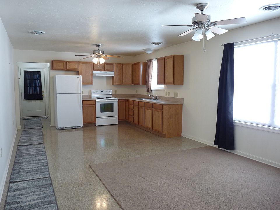 Open kitchen and dining room with abundant natural lighting and energy efficient windows with curtains.