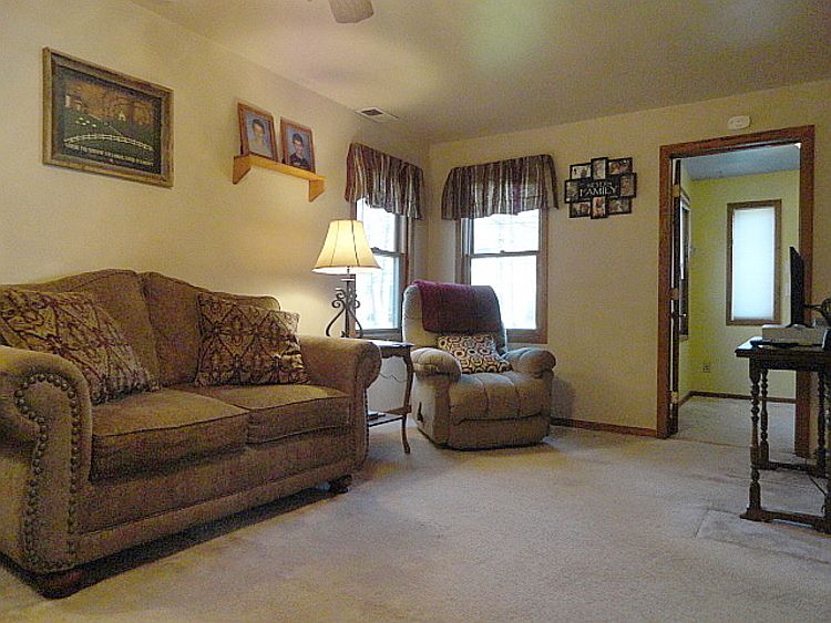 This 10 ft. by 19 ft. living room has neutral carpeting and plenty of always appreciated natural light!