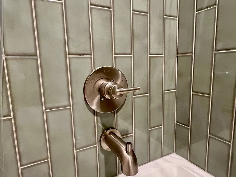 Detail of gorgeous subway tile laid vertically in the primary bathroom which has a tub/shower.