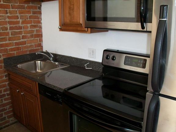 Exposed Brick, Granite Countertops and Stainless Steel Appli