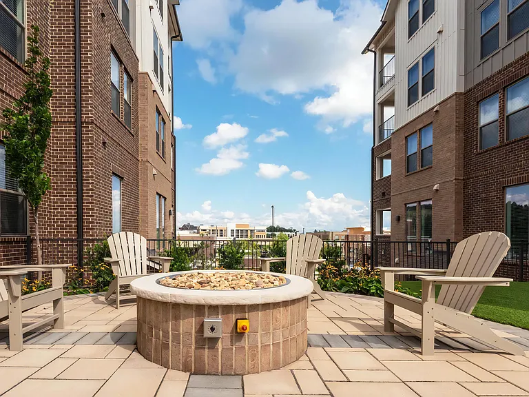 Outdoor Social Space with Fire Pit and Seating Between Apartment Buildings