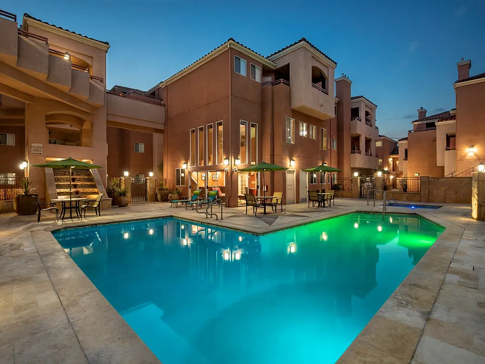 View of Lit Up Pool and Patio Tables