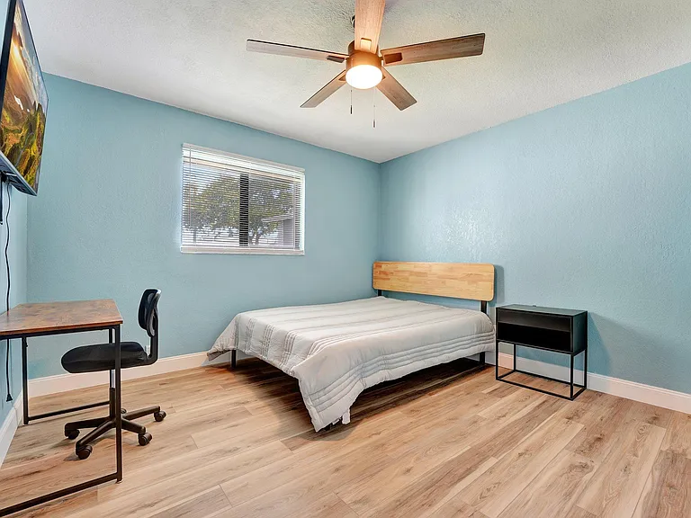 Bedroom with desk, tv and closet