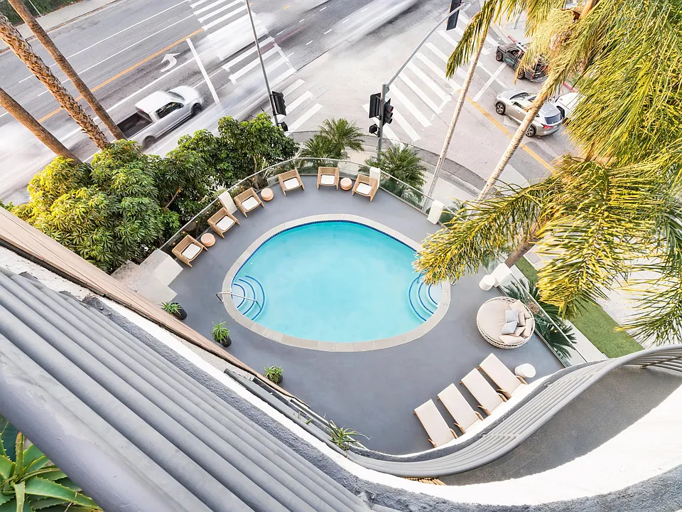 Resort-style pool deck with lounge seating and palm-lined views above the Sherman Oaks neighborhood.