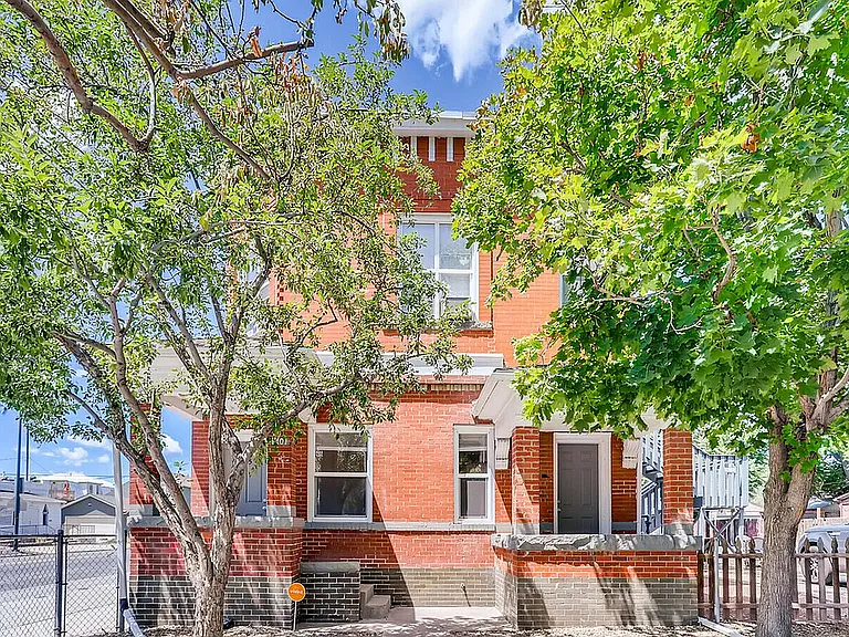 Experience the welcoming allure of this red brick home surrounded by lush greenery.