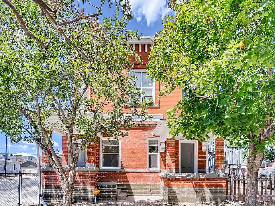Experience the welcoming allure of this red brick home surrounded by lush greenery.