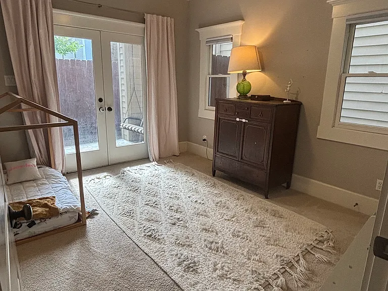 One of two bedrooms downstairs with access to the backyard through double french doors.